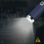 Parapluie pliant avec lumière LED éclairant un passage piéton urbain, pratique et sécurisé même par temps sombre.