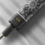 Parapluie pliant coloré avec motifs noir et blanc artistique, finition haut de gamme, parfait pour ajouter style et praticité.