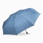 Parapluie pliant bleu élégant avec poignée en bois, compact et résistant, idéal pour se protéger de la pluie avec style.