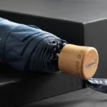Parapluie pliant denim avec poignée en bois, compact et élégant, parfait pour un style raffiné par temps de pluie.