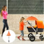 Parapluie poussette orange à clipser, pratique pour protéger du soleil. Mère au téléphone, enfant poussant la poussette.