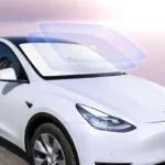 Pare-soleil parapluie rétractable protège le pare-brise d'une voiture blanche contre le soleil et la pluie, accessoire pratique.