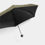 Parapluie compact noir à motifs de pois élégants, parfait accessoire mode pour rester au sec sous la pluie.