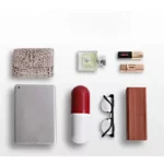 Petit parapluie capsule compact rouge et blanc avec accessoires modernes sur fond clair, idéal pour un usage quotidien pratique.