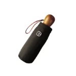 Parapluie compact noir avec poignée bois, housse élégante et lanière, idéal pour un style chic et pratique sous la pluie.
