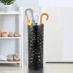 Porte-parapluie cylindrique noir élégant avec parapluies colorés dans une entrée moderne, idéal pour organiser avec style.