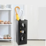 Porte-parapluie en métal noir design moderne avec motifs, idéal pour ranger des parapluies colorés près d'une étagère.