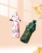 Parapluies femme chic : design floral rose et motifs dorés verts, accessoire élégant de la collection mode sur fond chaleureux.