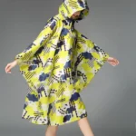 Poncho femme avec capuche élégant, design graphique coloré jaune, bleu et noir, idéal pour toutes saisons et occasions mode.