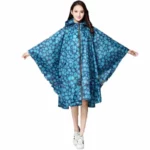 Femme avec poncho fleuri imperméable à capuche, élégant et pratique, parfait pour se protéger de la pluie avec style.