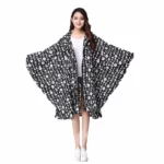 Poncho femme fleuri noir et blanc élégant, parfait pour affronter la pluie avec style et confort, collection tendance mode.