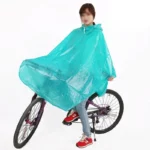 Femme avec poncho de pluie turquoise à pois sur un vélo, alliant style, confort et protection pour les cyclistes en toutes saisons.