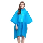 Poncho femme léger en plastique bleu, imperméable et élégant, parfait pour les journées pluvieuses, porté avec style et sourire.