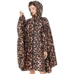 Femme élégante en poncho chic à imprimé léopard, moderne et pratique, parfait pour se protéger de la pluie avec style.
