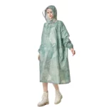 Poncho femme long vert menthe imperméable à capuche, motif feuilles blanches. Élégant et pratique pour les jours de pluie.