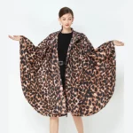 Poncho femme luxe au motif léopard, manches larges, accessoire élégant et imperméable pour se protéger de la pluie.