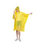 Femme portant un poncho transparent jaune avec capuche, léger et élégant, parfait pour la pluie et issu de la collection [Collection].