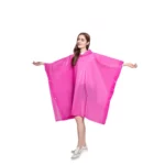Femme souriante avec poncho de pluie rose léger, bras ouverts, parfait pour un style tendance et pratique sous la pluie.