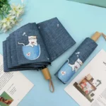 Parapluie automatique pliable motif chat, tissu denim, avec pochette, idéal pour ajouter du style à vos accessoires du quotidien.