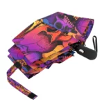 Parapluie pliable avec motifs de crânes colorés sur fond noir, design unique alliant style et protection contre la pluie.