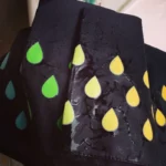 Parapluie noir motifs gouttes colorées vert/jaune, innovations couleurs changeantes, design unique, parfait pour jours de pluie.