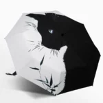 Parapluie noir et blanc avec motif chat stylisé, élégant et artistique, parfait pour fans de chats et accessoire tendance.