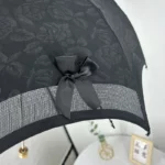 Parapluie cloche en dentelle noir avec motif floral et nœud satin, idéal pour un style élégant et raffiné, accessoire mode unique.