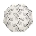 Parapluie femme élégant à motif floral noir et blanc, branches et fleurs sur fond crème, résistant et idéal contre la pluie.