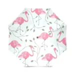 Parapluie pliant flamants roses avec feuilles sur fond blanc, accessoire tendance pour se protéger de la pluie avec élégance.