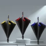 Parapluies golf résistants avec bords colorés (jaune, rouge, bleu) sur fond minimaliste, idéal pour les amateurs de golf.