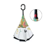 Parapluie inversé résistant avec motif floral coloré, poignée ergonomique en H et bouton rouge pour fermeture facile.
