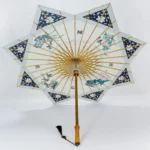 Parapluie japonais octogonal en papier, motifs floraux et géométriques, structure en bois doré, élégant et artisanal.