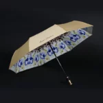Parapluie luxe beige avec motif floral bleu, résistant et élégant, parfait pour allier style et protection sous la pluie.