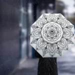 Parapluie mandala noir et blanc élégant sous la pluie, alliant style et protection, parfait pour les amateurs de motifs artistiques.