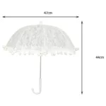 Parapluie mariage romantique en dentelle blanche avec pompons décoratifs, idéal pour une cérémonie élégante et chic.