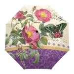 Parapluie nature avec motifs de fleurs roses, papillon, et ornements dorés-violets sur un fond raffiné et élégant.