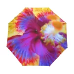 Parapluie pliant à motifs floraux colorés, avec dégradés de rose, violet, jaune et orange, élégant et pratique pour la pluie.