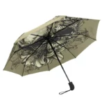 Parapluie pliant gothique noir et beige, motifs floraux élégants, style artistique et pratique pour affronter la pluie avec élégance.