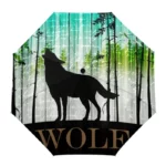 Parapluie pliant avec motif de loup noir dans une forêt stylisée, dégradé vert-bleu en arrière-plan, design unique et élégant.