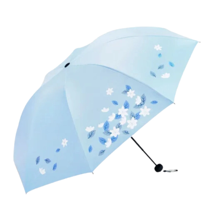 Parapluie pliant manuel bleu avec motifs floraux blancs et verts, pratique et élégant pour se protéger de la pluie avec style.