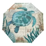 Parapluie pliant océan avec tortue marine turquoise, carte nautique, plantes marines et étoiles de mer, design élégant et pratique.