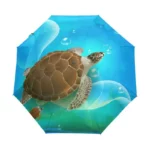 Parapluie pliant océan avec motif tortue nageant sous l'eau, bulles d'air et fond bleu, style élégant et pratique pour la pluie.