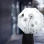 Parapluie pliant thème pissenlit, élégant et compact, avec motifs floraux et papillons, idéal pour la pluie et facile à transporter.