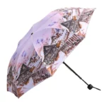 Parapluie rétro avec motif de maisons en bois sur fond pastel, élégant et fonctionnel pour se protéger de la pluie avec style.