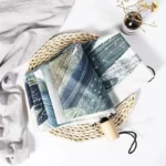 Parapluie robuste et élégant, design artistique, posé sur support en osier avec écharpe grise et vase décoratif, idéal pluie.