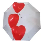 Parapluie blanc avec cœurs rouges en ballon, accessoire romantique idéal en pluie pour célébrer l'amour avec élégance.