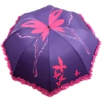 Parapluie vintage violet avec motifs papillons roses et bordure froncée, élégant et pratique pour affronter la pluie avec style.