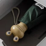 Petit parapluie grenouille ludique, design en bois, revêtement vert, cordon de transport, parfait pour enfants, emballage soigné.