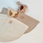 Poncho bébé avec capuche, collection tendance, design animal en relief, crème et beige, pratique et élégant pour protéger de la pluie.