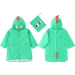 Poncho bébé dinosaure vert avec capuche imperméable, détails ludiques et sacoche assortie. Parfait pour protéger les enfants sous la pluie.